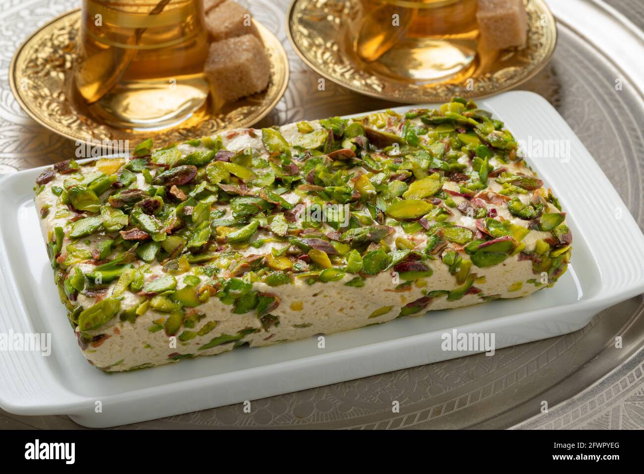 Teller mit traditioneller türkischer Pistazien-Halva-Nahaufnahme und Tee Stockfoto