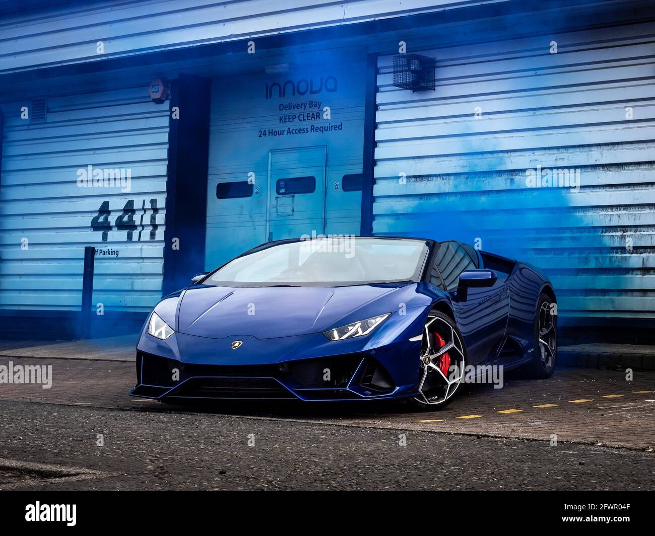 Lamborghini huracan evo spyder vor einem Industriegebäude mit blauer Farbe Rauch Stockfoto