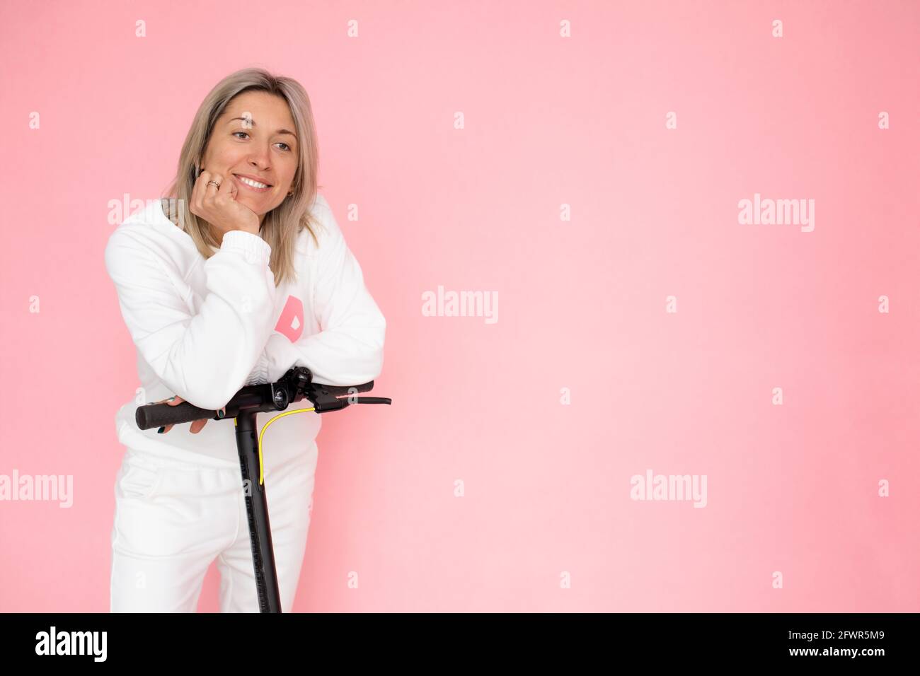 Blonde Frau glücklich, Elektroroller, alternative Verkehrsträger Konzept zu kaufen Stockfoto