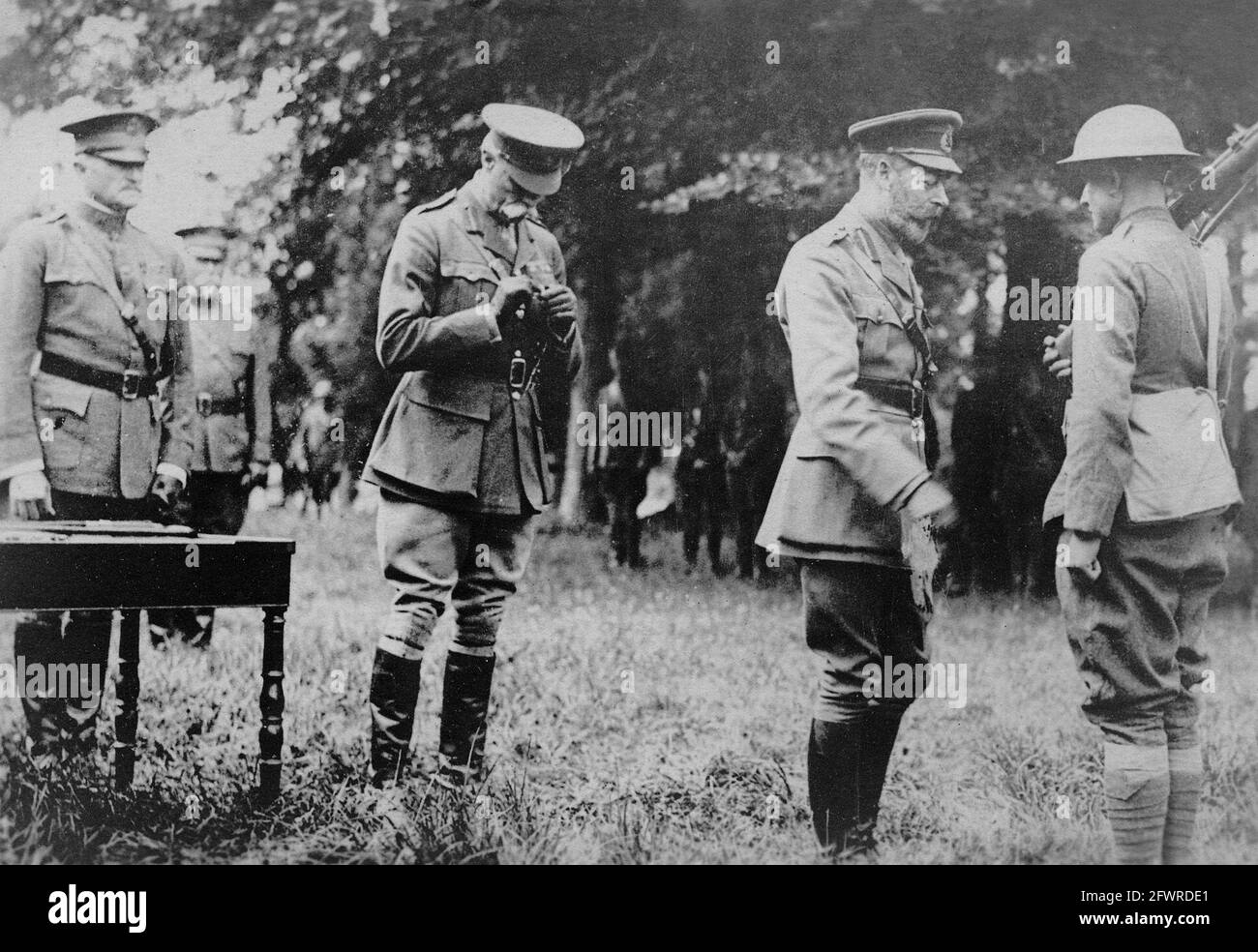 In Anwesenheit von General Pershing schmückt König George V. einen amerikanischen Soldaten für die Galanterie. Stockfoto