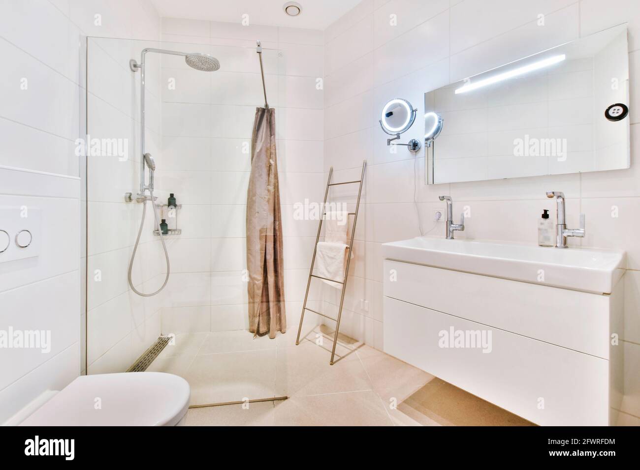 Moderne Innenausstattung des Waschraums mit Duschkabine aus Glas und Weiß Wandtoilette mit Bidet Stockfoto