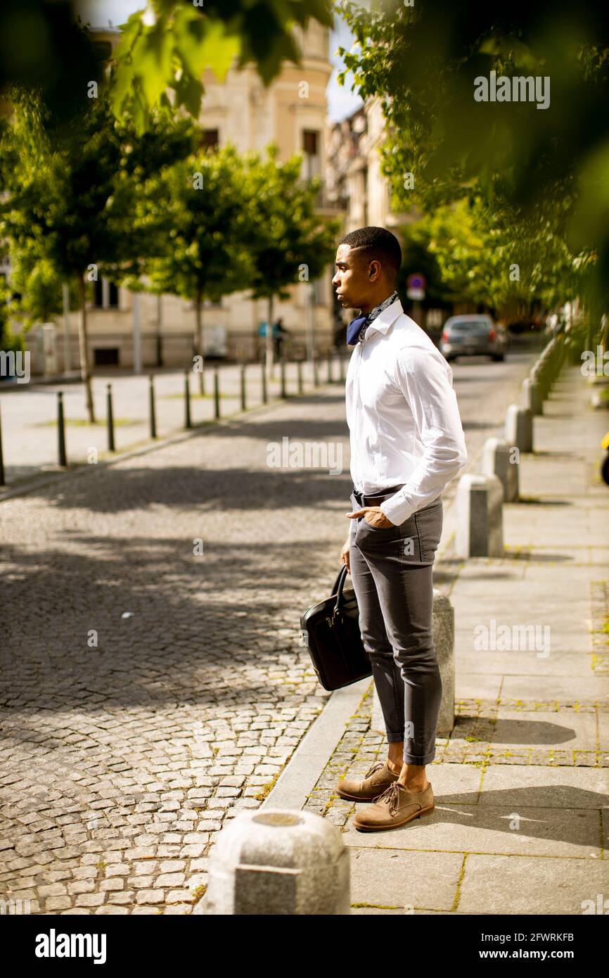 Ein hübscher junger afroamerikanischer Geschäftsmann wartet auf ein Taxi Straße Stockfoto