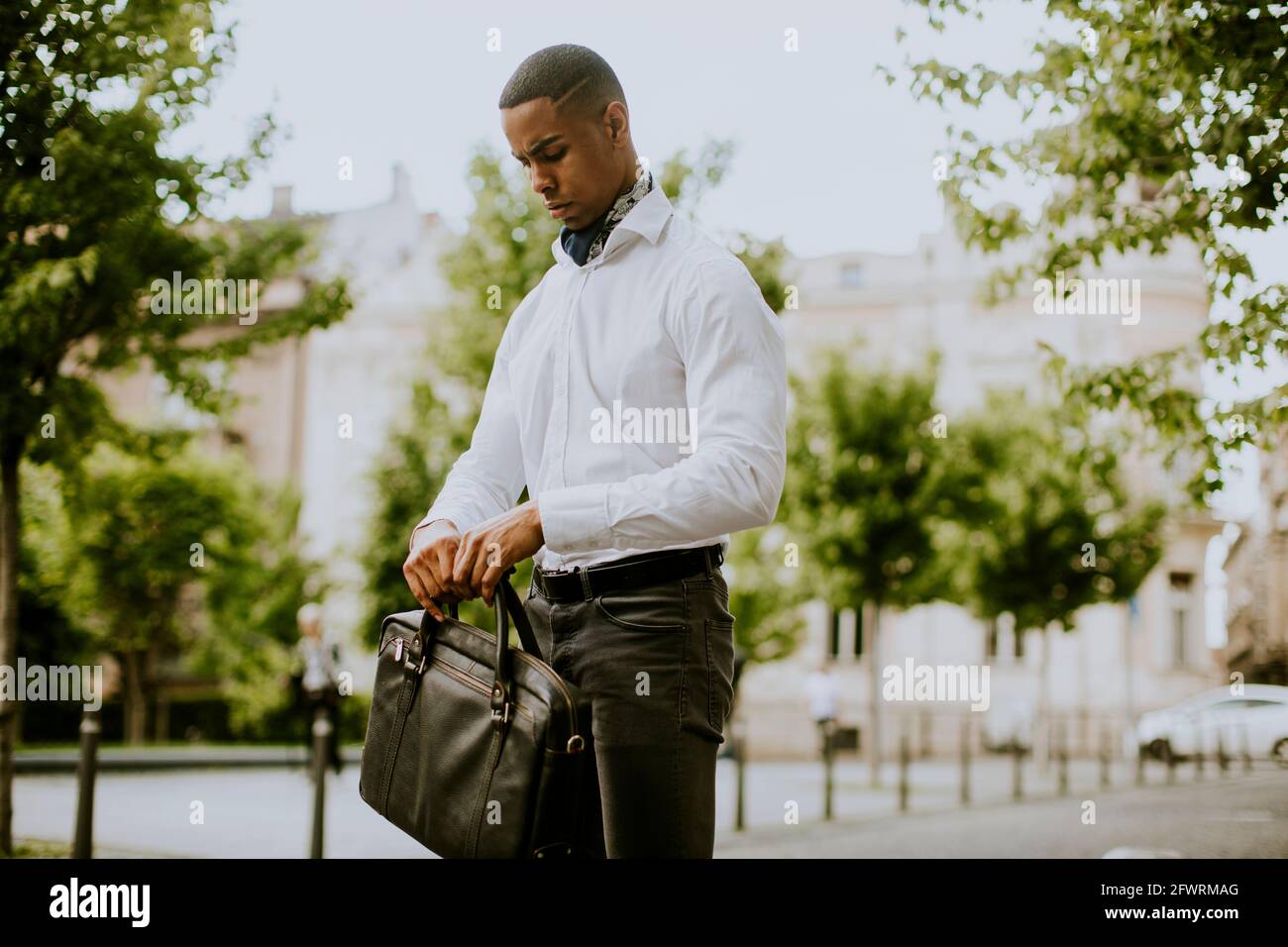 Ein hübscher junger afroamerikanischer Geschäftsmann wartet auf ein Taxi Straße Stockfoto