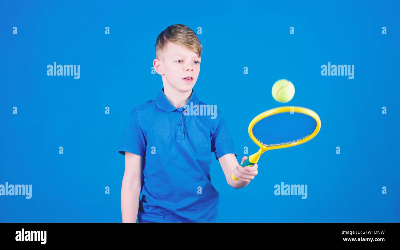 Athlet Kinder Tennisschläger auf blauem Hintergrund. Tennis Sport und Unterhaltung. Junge Kind spielt Tennis. Tennisspielen üben. Kerl mit Schläger genießen Stockfoto