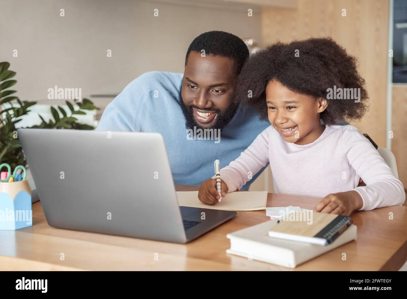 Kopf Schuss lächelnd Vater und Tochter beobachten lustige Video studieren Zu Hause Stockfoto