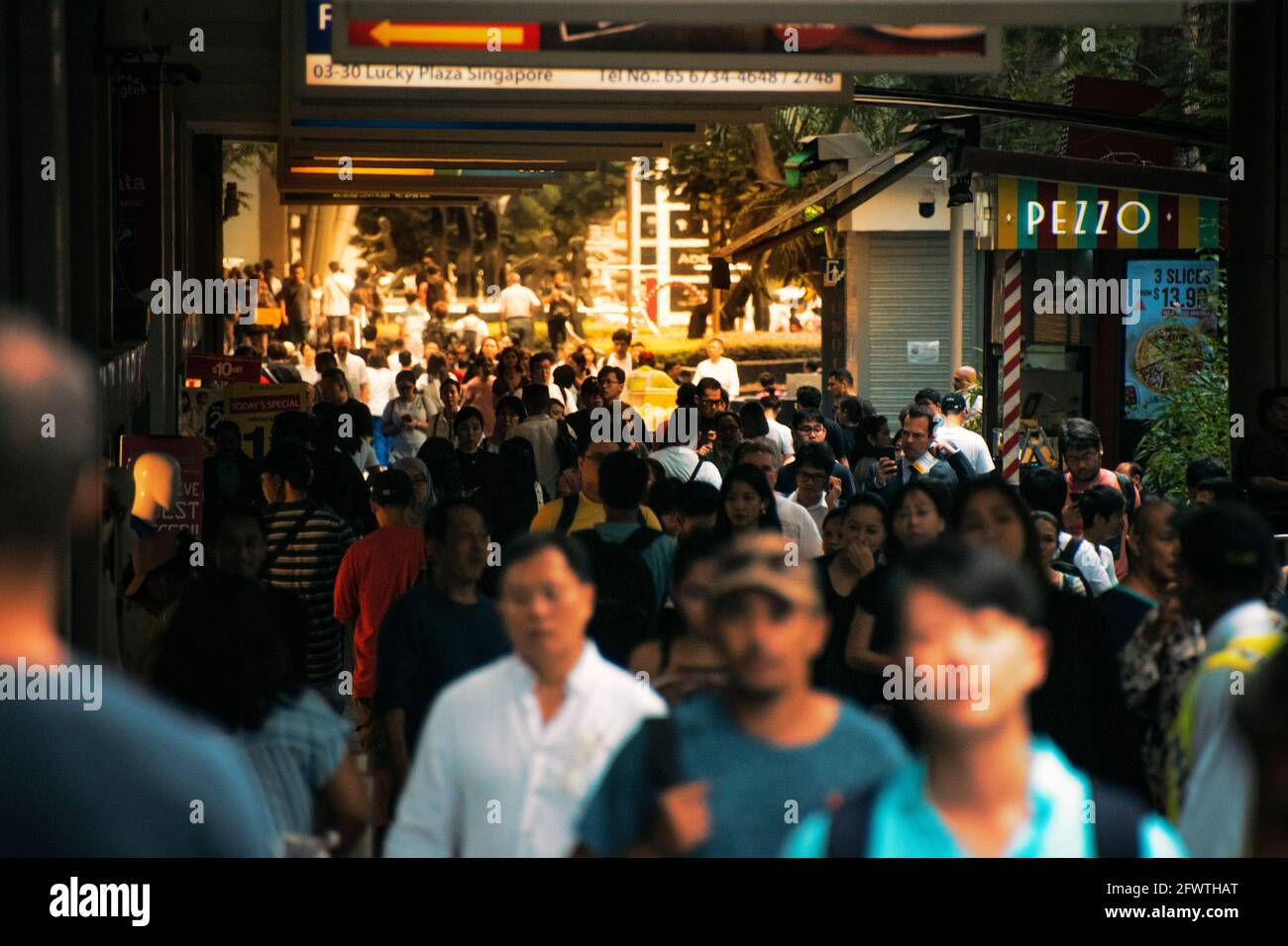 Eine vielfältige Menschenmenge überquert die Orchard Road, Singapur. Stockfoto
