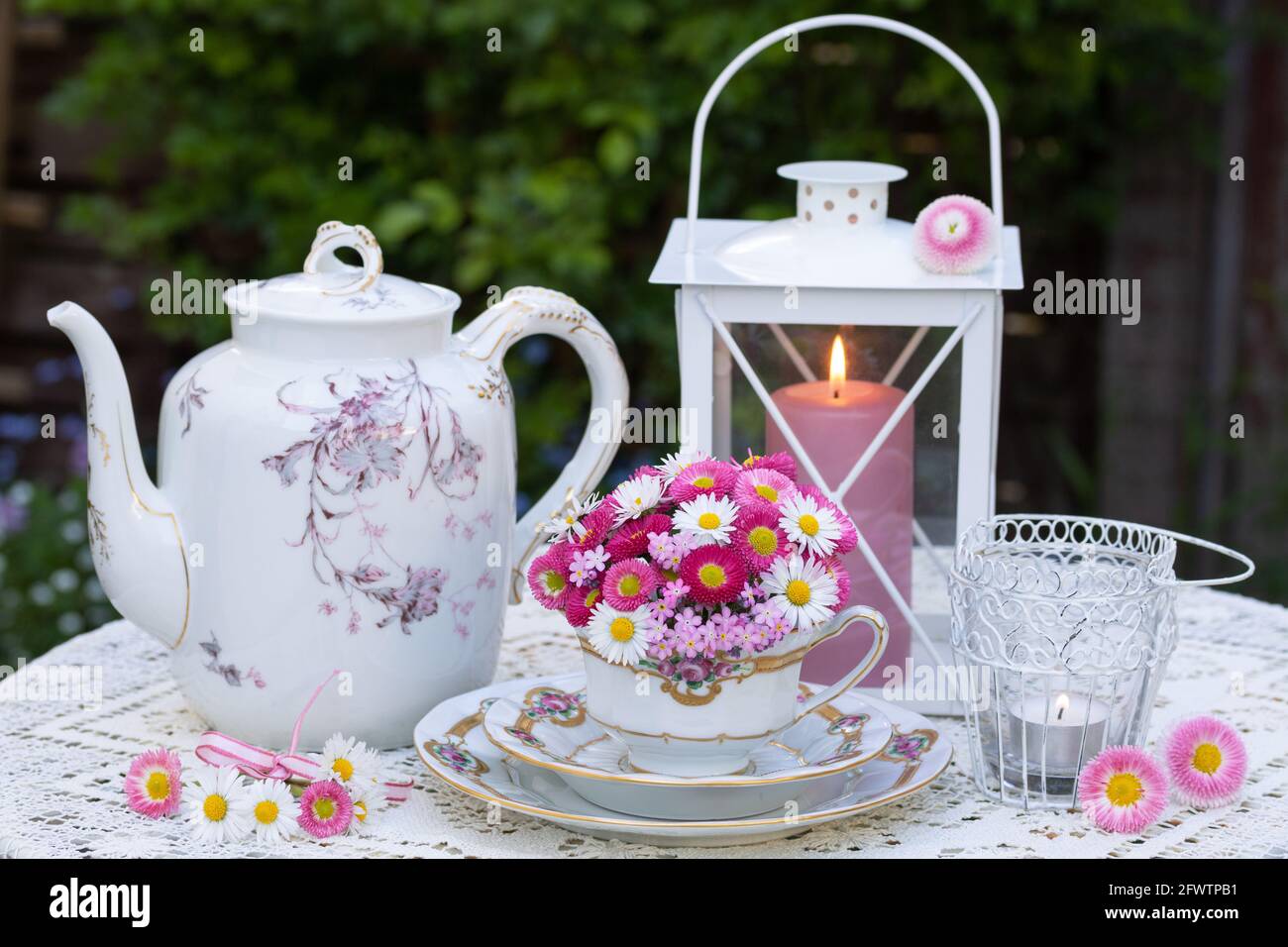 Romantische Dekoration mit Bouquet von rosa bellis Blumen und Gänseblümchen Und Vintage Porzellan Stockfoto