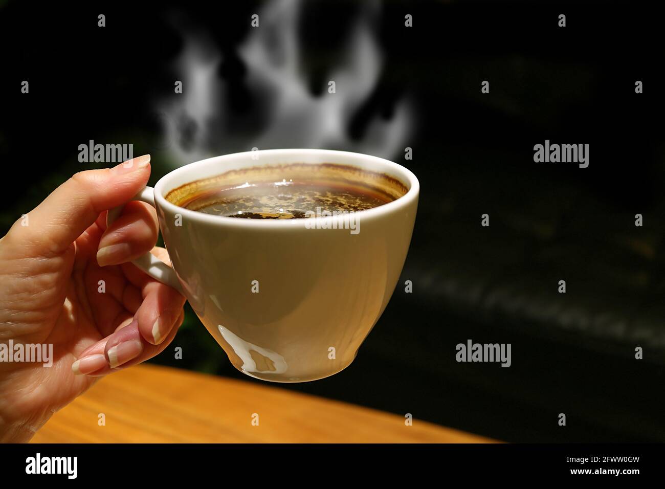 Tasse aromatischen heißen Kaffee mit ansteigendem Dampf im Damencafé Hand Stockfoto