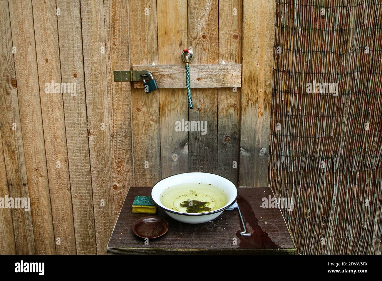 Der einfache Waschraum mit nur kaltem Wasser und Emaille-Becken. Sieht rustikal und schlecht aus Stockfoto