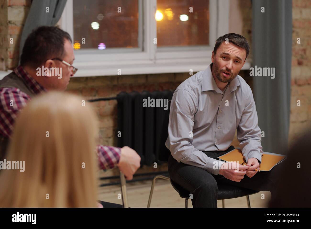 Ältere und Männer mittleren Alters diskutieren psychologische Probleme während der Sitzung Stockfoto