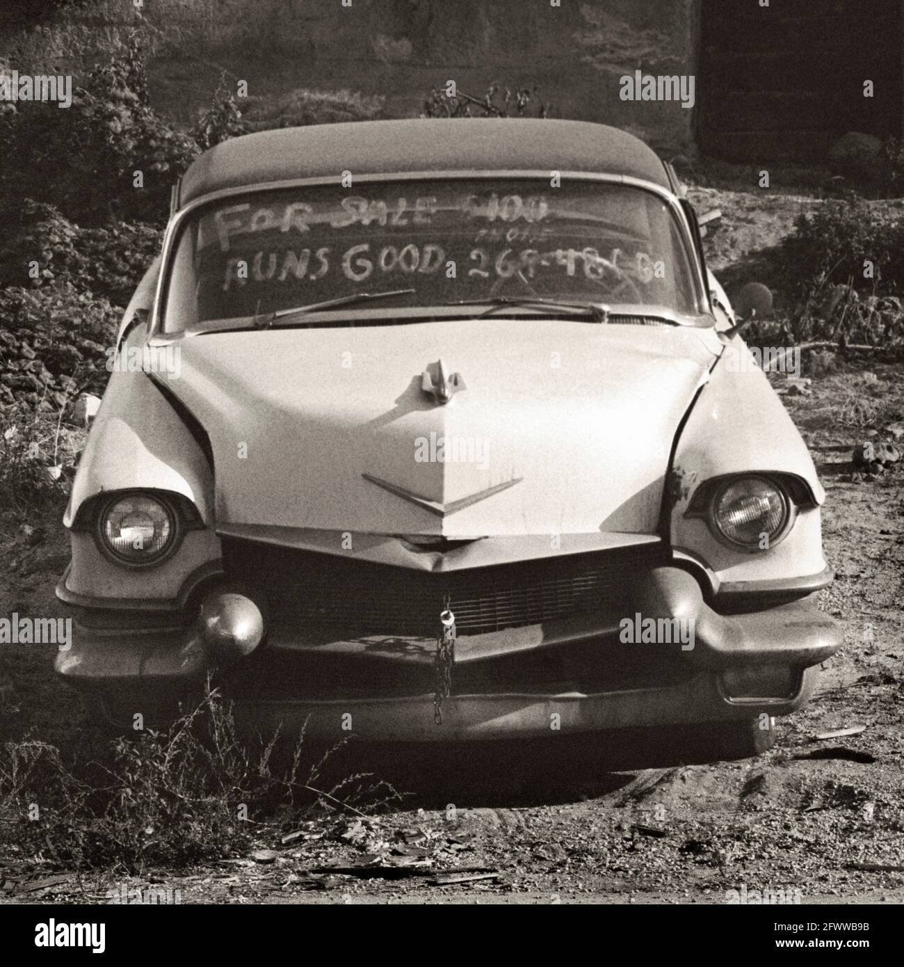 Ein mögliches Cadillac-Automobil aus dem Jahr 1956; mit „Runs Good“ auf der Windschutzscheibe. Beachten Sie die Kette, mit der die Haube befestigt ist. Stockfoto