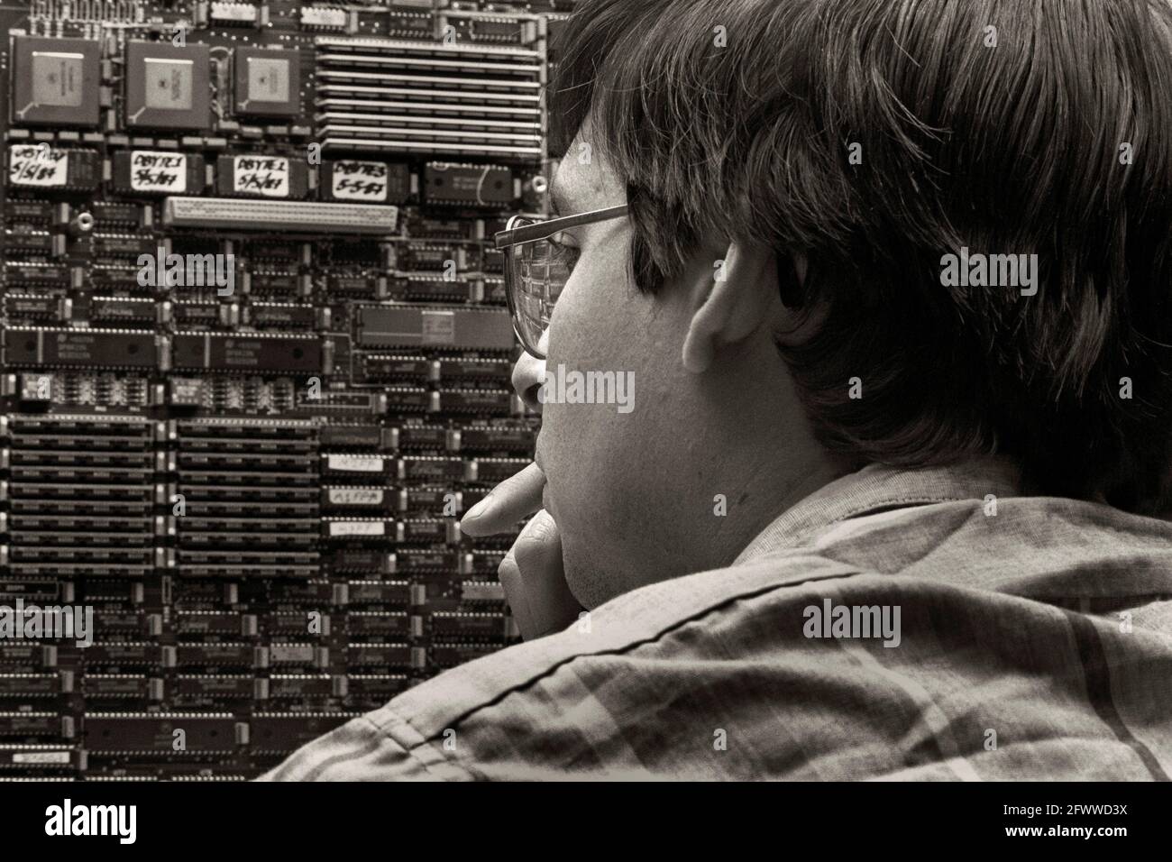 Ein Mark III Hyperwürfel-Computer mit einem Techniker im Jet Propulsion Laboratory; 1988. Jede Platine besteht aus einem Knoten in der Parallel-Computing-Gesamtheit. Der Mark III Hypercube integriert 128 Nodes; jeder Node verfügt über die Leistung von 25 VAX-Minicomputern.? Die Höchstgeschwindigkeit beträgt 2 Milliarden Gleitkommavorgänge pro Sekunde.? Mit Motorola 68020 Mikroprozessoren gebaut.? Ein gemeinsames Unterfangen von Caltech und JPL.? Stockfoto