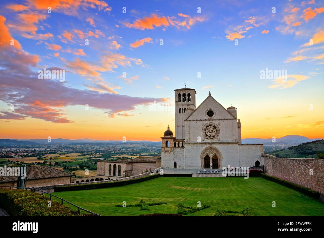 Basilika San Francis of Assisi bei Sonnenuntergang unter einem wunderschönen, orange-blauen Himmel, Italien Stockfoto