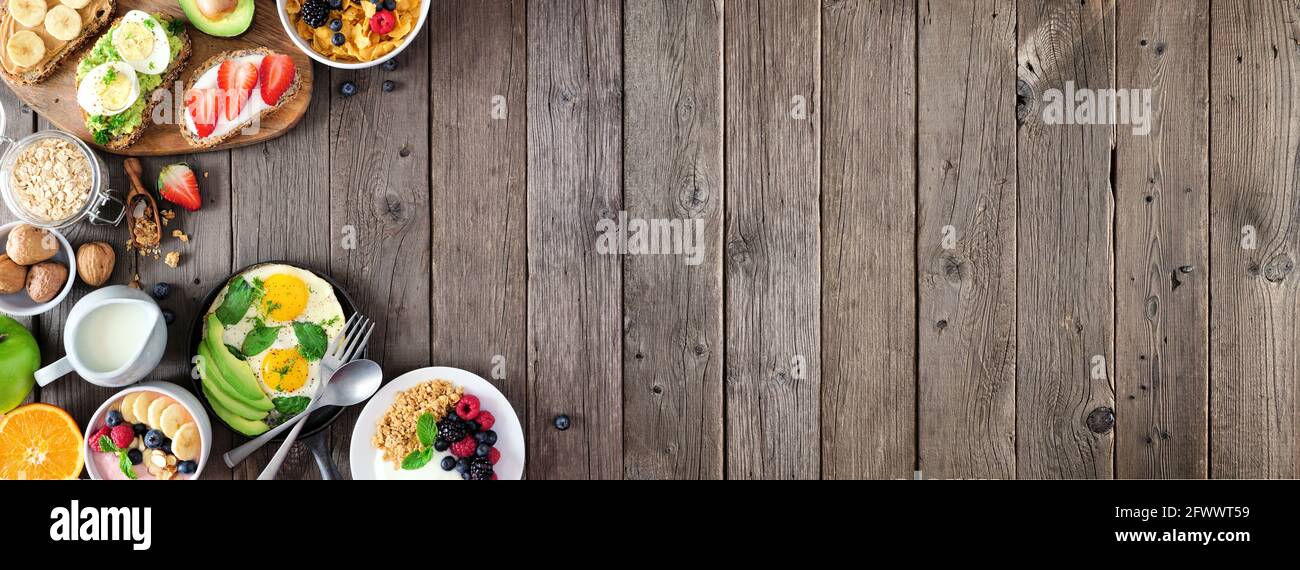 Banner mit gesunden Frühstücksnahrung und Seitenrand. Tischszene mit Obst, Joghurt, Smoothie-Schüssel, nahrhaftem Toast, Müsli und Eierpfanne. Draufsicht Ove Stockfoto