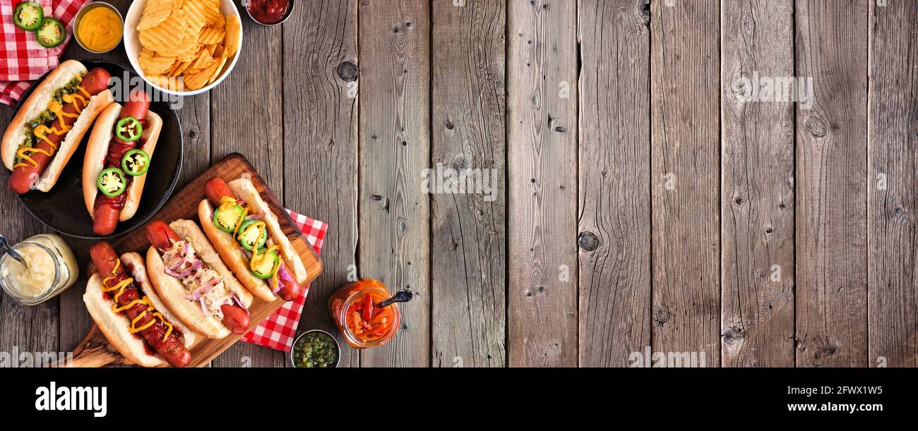BBQ Hot Dog Ecke Grenze. Draufsicht Tischszene mit einem dunklen Holz Banner Hintergrund. Speicherplatz kopieren. Stockfoto