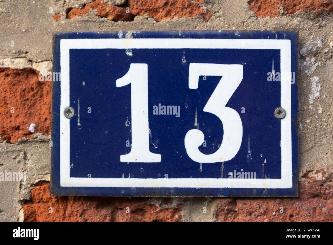 Nummer 13 in weiß auf einer blauen Metallplatte Stockfoto