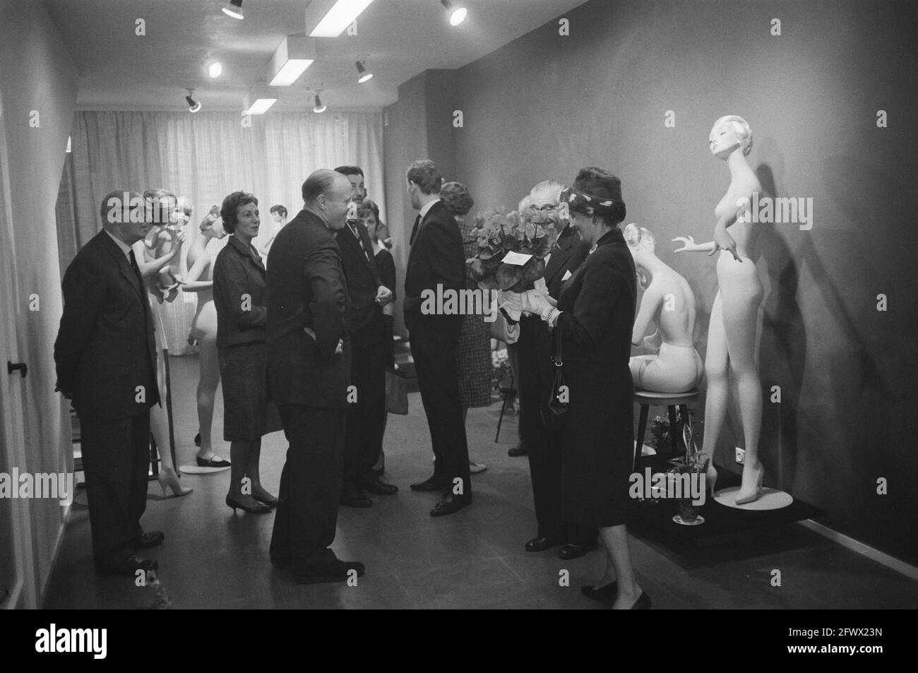 anbu-Zuweisungen Drost in Amsterdam [Gesellschaft im Zimmer mit Schaufensterpuppen. Frau mit Blumentopf mit Cyclamen und Karte], 18. November 1960, Puppen, Empfänge, Niederlande, Presseagentur des 20. Jahrhunderts, Foto, Nachrichten zum erinnern, Dokumentarfilm, historische Fotografie 1945-1990, visuelle Geschichten, Menschliche Geschichte des zwanzigsten Jahrhunderts, Momente in der Zeit festzuhalten Stockfoto