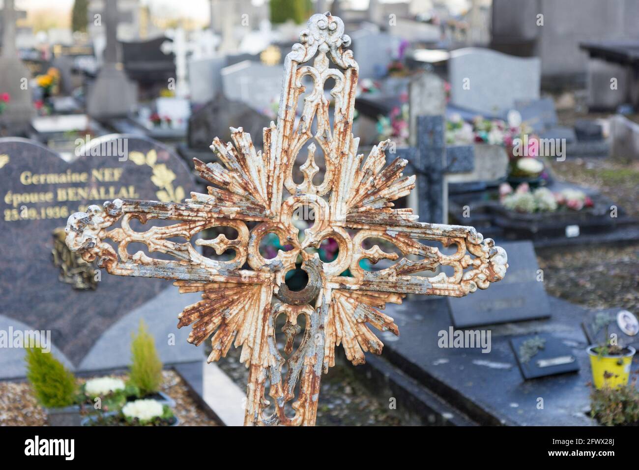Ein altes, rostiges Metallornamentkreuz auf einem Grabstein auf dem Friedhof von Saint Roch. Valenciennes, Frankreich, 2017-01-05. Stockfoto