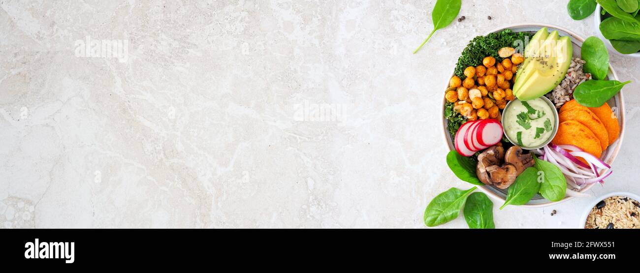 Gesunde vegane Mittagsschale mit Avocado, Süßkartoffeln, Grünkohl und Gemüse. Seitenrand auf weißem Stein Banner Hintergrund. Gesunde Ernährung Konzept. Stockfoto