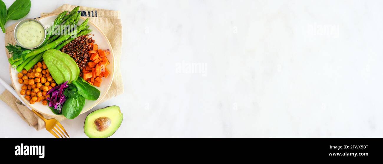 Gesunde Buddha-Schale mit Spargel, Quinoa, Süßkartoffeln, Kichererbsen und Avocado. Über Ansicht Seitenrand über einem weißen Marmorbanner Hintergrund. Stockfoto