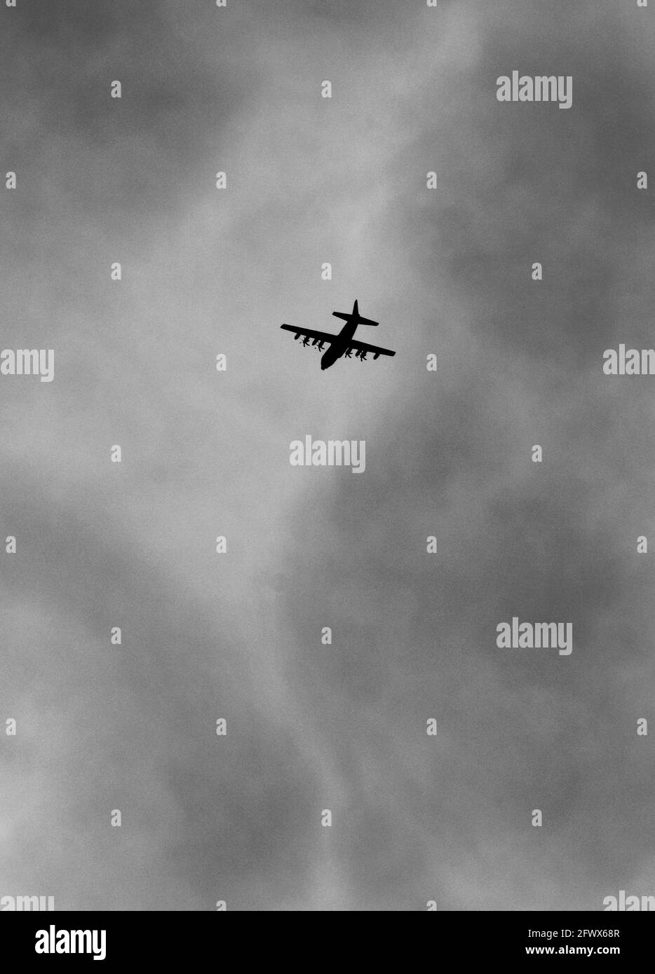 Ein Frachtflugzeug der US-Militärluftwaffe Lockheed C-130 Hercules Air Force wird gegen den Himmel silouettiert, während es über New Mexico fliegt Stockfoto