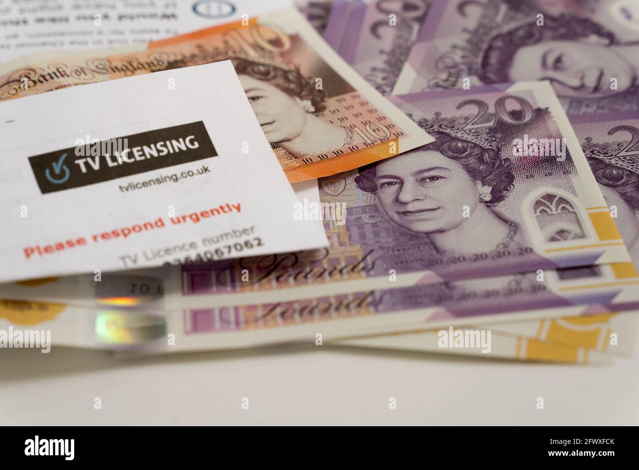 Stapel von Sterling Pfund Bank of England stellt £20 auf weißem Hintergrund , TV-Lizenzschreiben Rechnung zu bezahlen Stockfoto