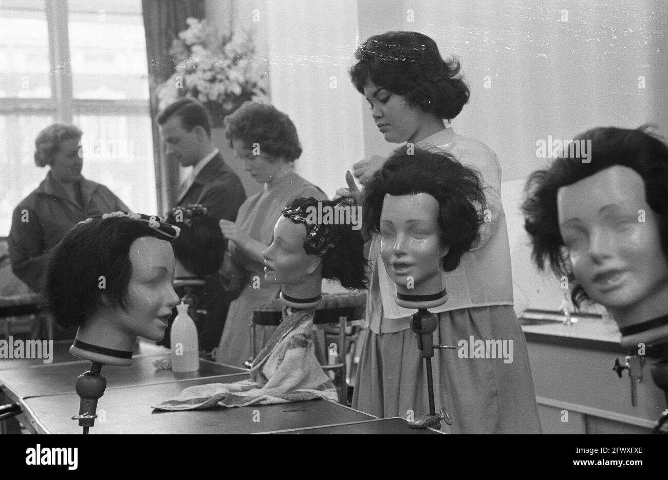 Eröffnung der ersten Friseurtagesschule in der Prinses Mariekestraat in Den Haag, einige Studenten üben, 29. Februar 1960, LEERLINGEN, Öffnen Stockfoto
