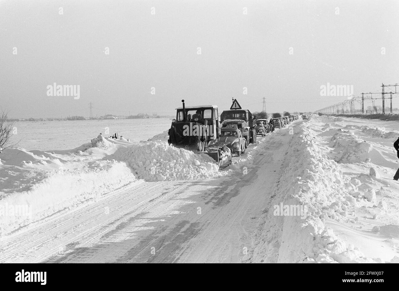 Provinzstraße von Krommenie nach Uitgeest, Verkehr war nur hinter einer Planierraupe möglich, 20. Januar 1963, Planierraupen, Schnee, Niederlande, 20. Jahrhundert Stockfoto