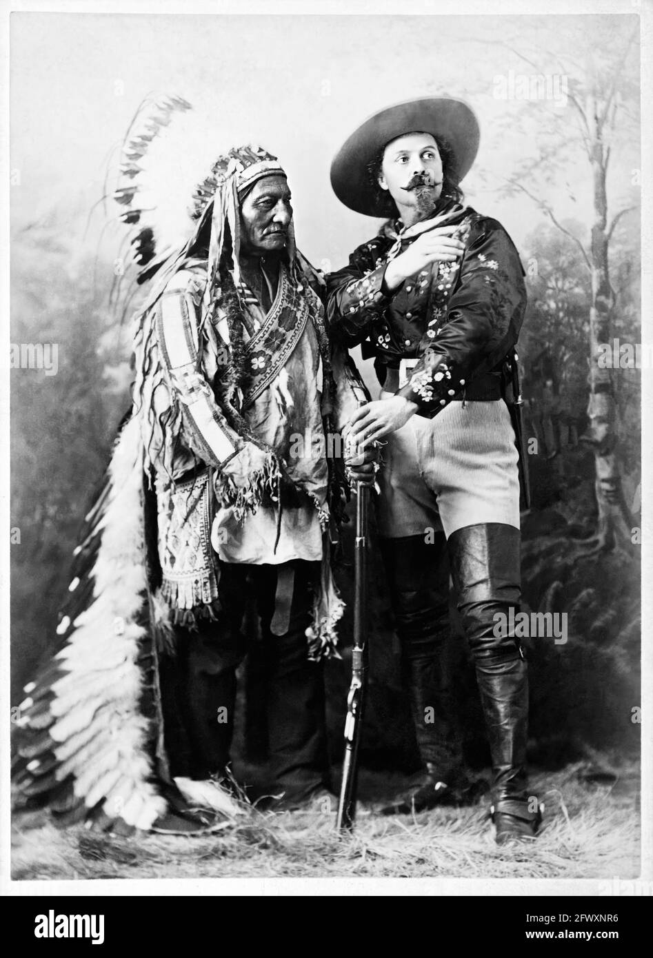 1880 Ca, Montreal, KANADA: Der gefeierte Colonel William Frederick CODY, bekannt als BUFFALO BILL (1846 - 1917) mit Chef SITZENDEN STIER (1831 - 1890) von Sioux Hunkpapa zur Zeit der WILDEN WEST-SHOW. Foto von W.M. Notman & Son, Montreal. - Epopea del Selvaggio WEST - Cowboy - Cow-boy - Circus - uomo anziano vecchio - älterer Mann - Baffi - barba - Bart - Schnurrbart - Circo - Hut - cappello - piume - Federn - Indianer Amerikas - Indiani d'America - Indianer - Nativi americani - Pellerossa - Rothäute - fucile - Gewehr - Waffe - arma - Stiefel - Stivali --- Archivio GBB Stockfoto