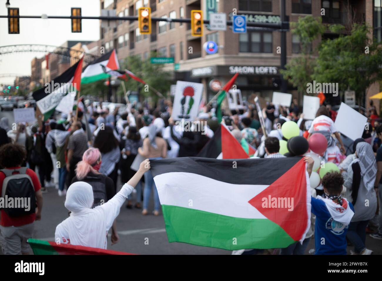 Columbus, Ohio, USA. Mai 2021. Demonstranten marschieren auf der North High Street im Short North District, während sie verschiedene palästinensische Flaggen halten.Demonstranten versammelten sich im Goodale Park in Columbus, Ohio, um sich zu versammeln und gegen die israelische Besetzung Palästinas zu marschieren. Die Demonstranten marschierten stundenlang vom Goodale Park auf und ab in der North High St. und verstopften einige der Hauptstraßen, bis die Demonstranten sich zurück zum Goodale Park machten, um eine Kerzenlichtmahnwache für diejenigen zu halten, die während der Besetzung Israels gestorben sind. Kredit: Stephen Zenner/SOPA Images/ZUMA Wire/Alamy Live Nachrichten Stockfoto