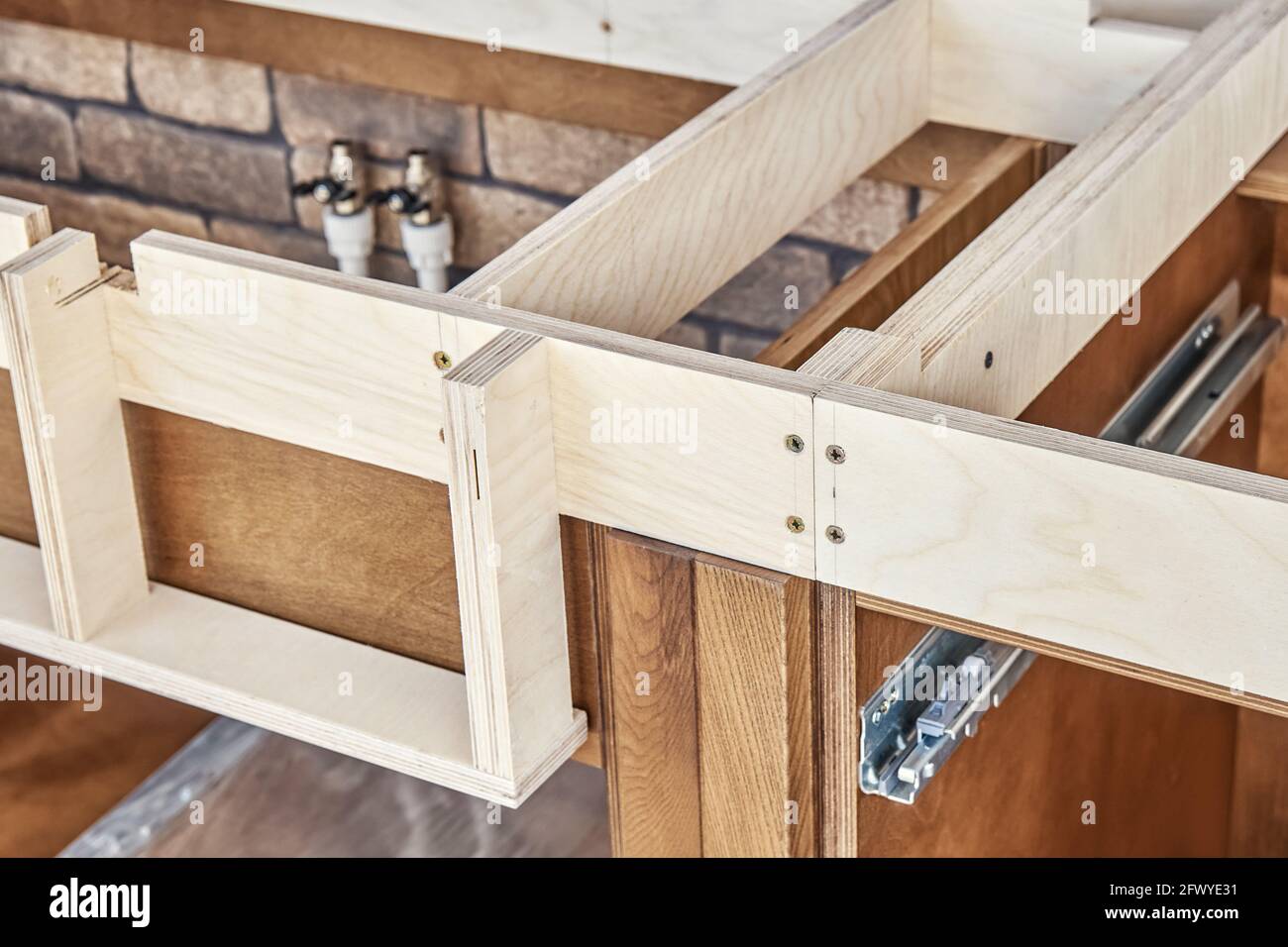 Holzkisten von Küchenmöbeln aus Sperrholz und massiv Holzasche mit einem eingebauten Sperrholzrahmen für die Arbeitsplatte In der Nähe Ziegelmauer extreme closeu Stockfoto