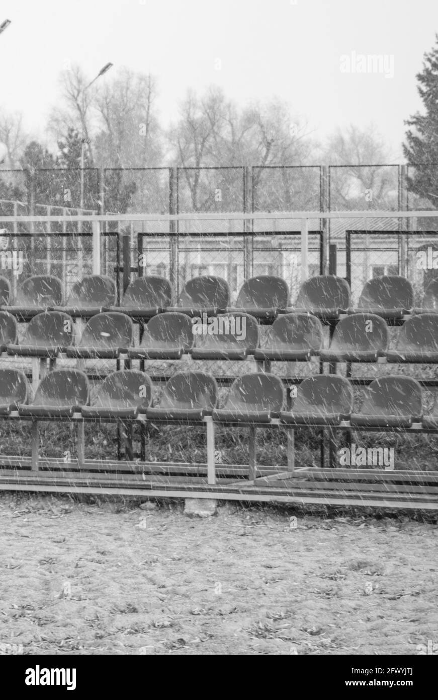 Nahaufnahme eines Teils der leeren Sitze in der Tribüne am Beachvolleyballstadion im Freien, vertikaler schwarz-weißer Rahmen Stockfoto