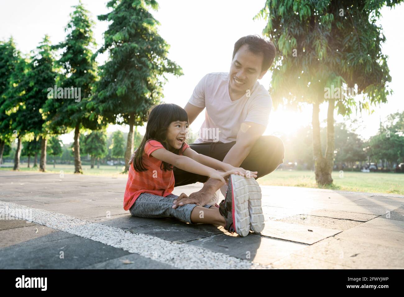 Vater und kleine Tochter machen Übungen im Freien. Gesunder Lebensstil der Familie mit Kind Stockfoto