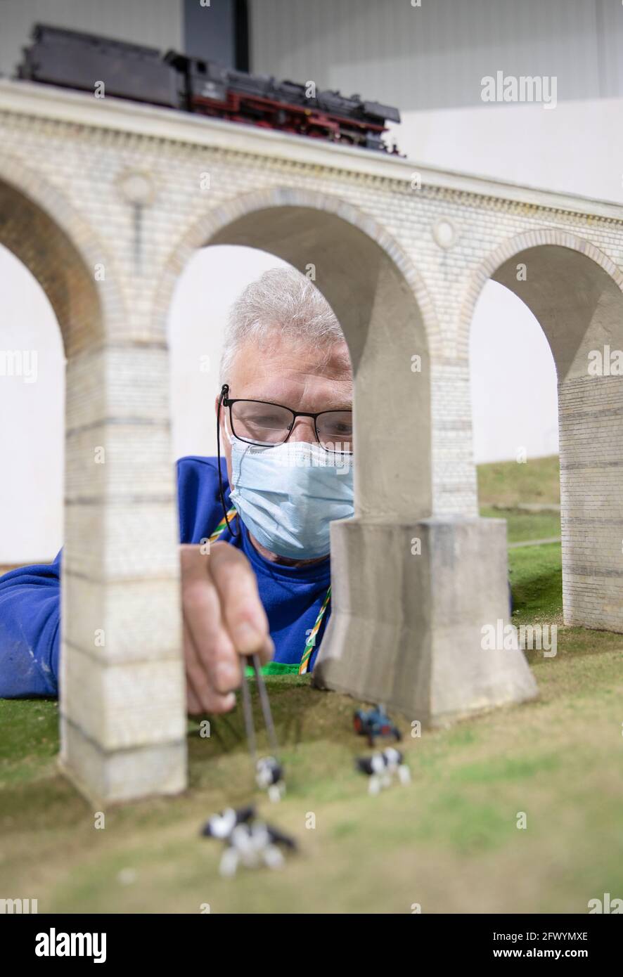 Brakel, Deutschland. April 2021. Modelleisenbahnbaumeister Michael Butkay  arbeitet am Bau der sogenannten Modellbundesbahn. Die Modelleisenbahn ist  eine Modelleisenbahn, die für die Öffentlichkeit zugänglich ist und die  Bahnhöfe Ottbergen und Bad ...