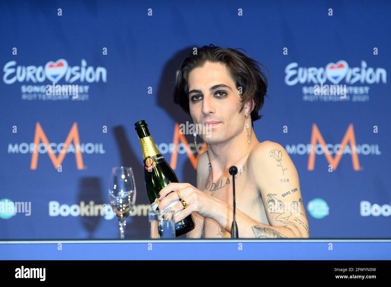 Rotterdam, Niederlande. Mai 2021. Sänger Damiano von der Band 'Maneskin' (Italien) gießt sich Champagner während einer Pressekonferenz, nachdem er den Eurovision Song Contest (ESC) gewonnen hat. Der Sänger trägt auf seiner Brust ein Tattoo mit dem Titel „Il ballo della vita (der Tanz des Lebens)“. Quelle: Soeren Stache/dpa-Zentralbild/dpa/Alamy Live News Stockfoto