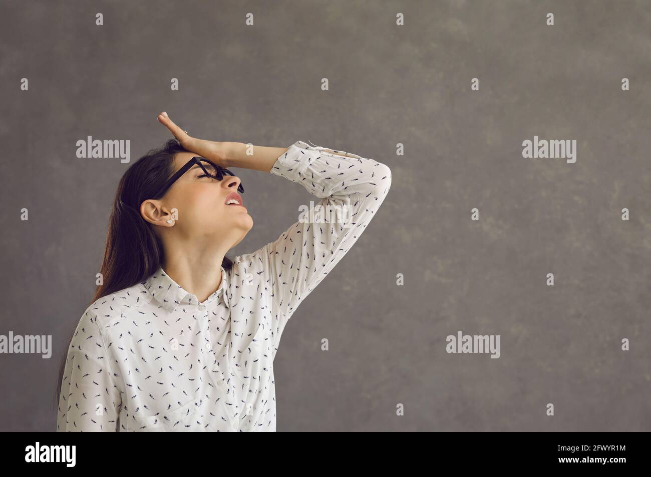 Junge kaukasische Frau, die die Stirn berührt, bedauert, dass sie falsch geschossen hat Stockfoto