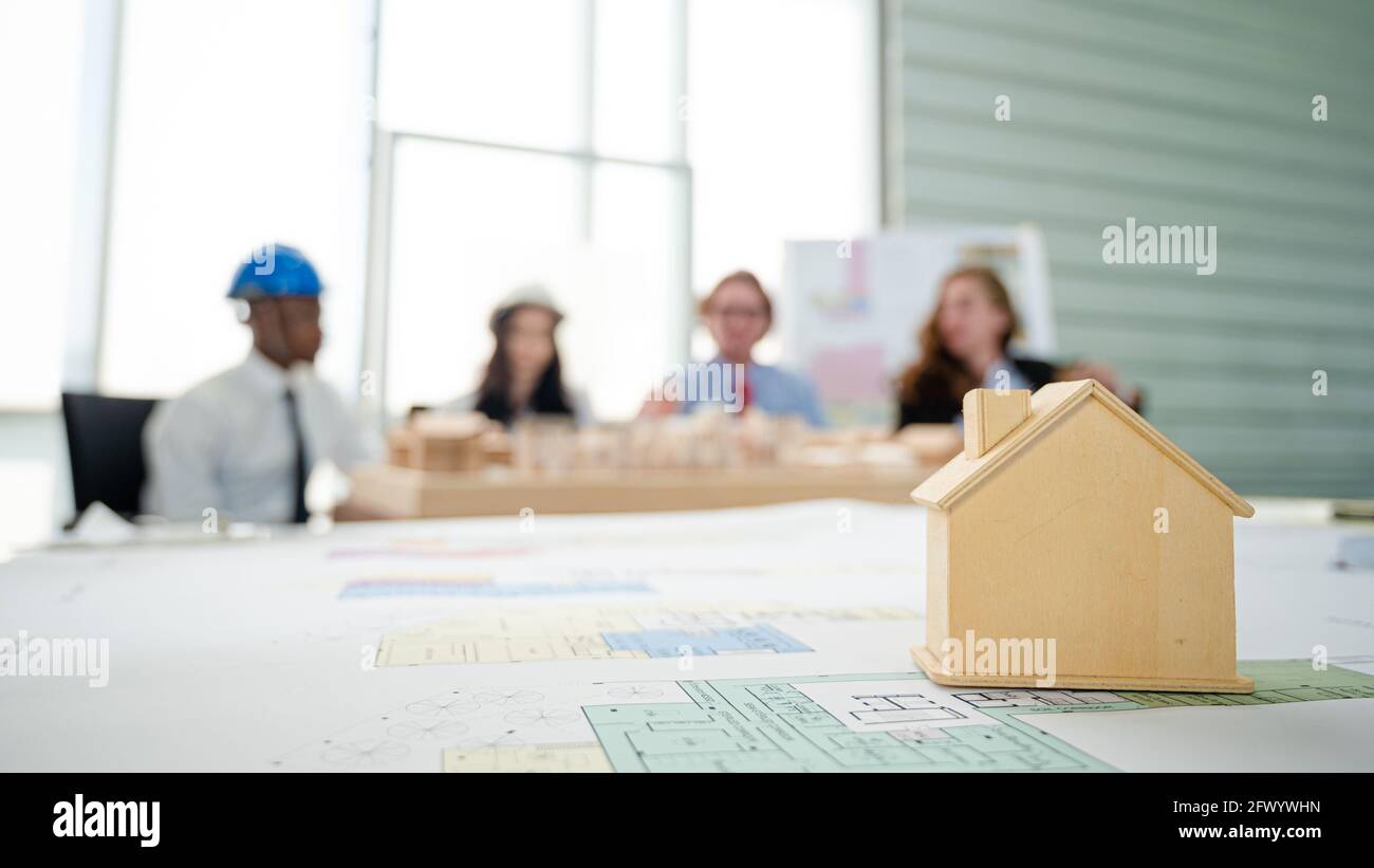 Nahaufnahme Gebäude Modell-Projekt auf dem Tisch mit Menschen treffen sich im Hintergrund. Immobilien Geschäftskonzept. Stockfoto