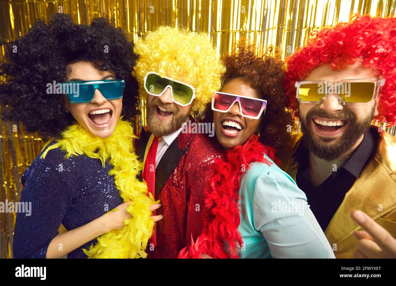 Aufgeregt gemischte Rennfreunde in farbigen Haarperücken Abschied posieren Für das Kameraporträt Stockfoto