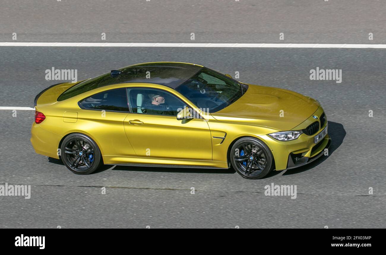 2014 BMW M4 gelbes 2978cc Benzincoupé; Fahrzeugverkehr, bewegliche Fahrzeuge, Autos, Fahrzeug auf britischen Straßen, Motoren, Fahren auf der Autobahn M6, britisches Straßennetz. Stockfoto