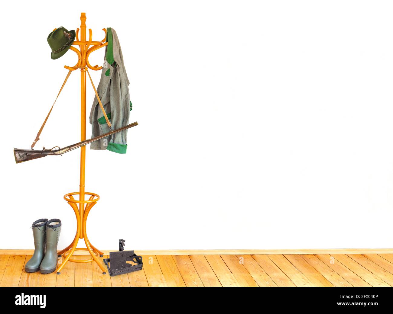 In einem leeren Raum hängt die Ausrüstung des Jägers am Kleiderhaken. Stockfoto