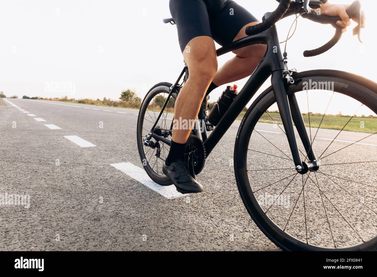 Professioneller Radfahrer, der Fahrrad auf asphaltierter Straße fährt Stockfoto