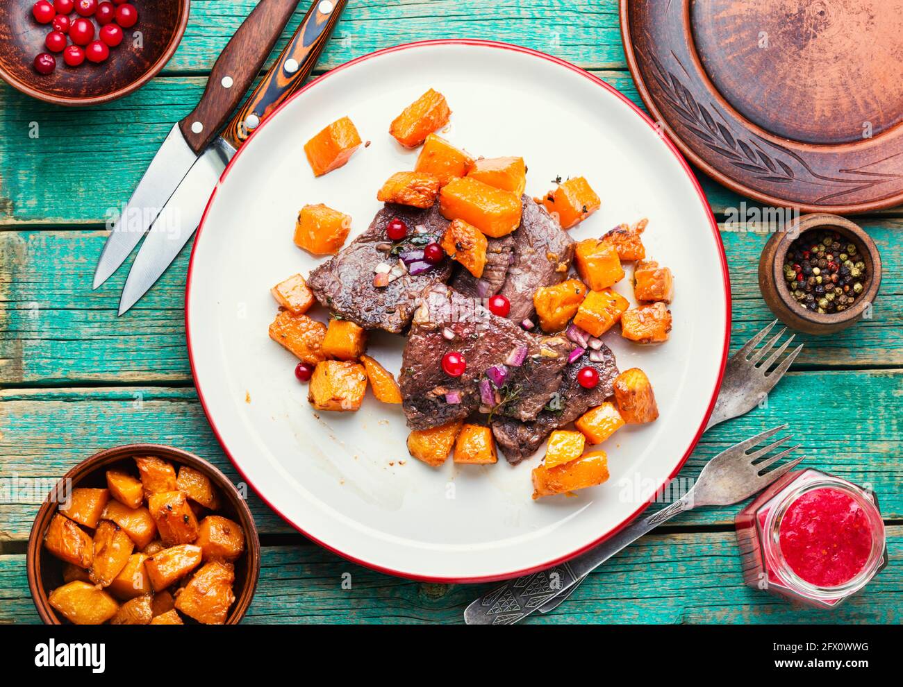 Rindersteaks mit Kürbisstücken gekocht.Kalbsfleisch mit Cranberry-Sauce. Stockfoto