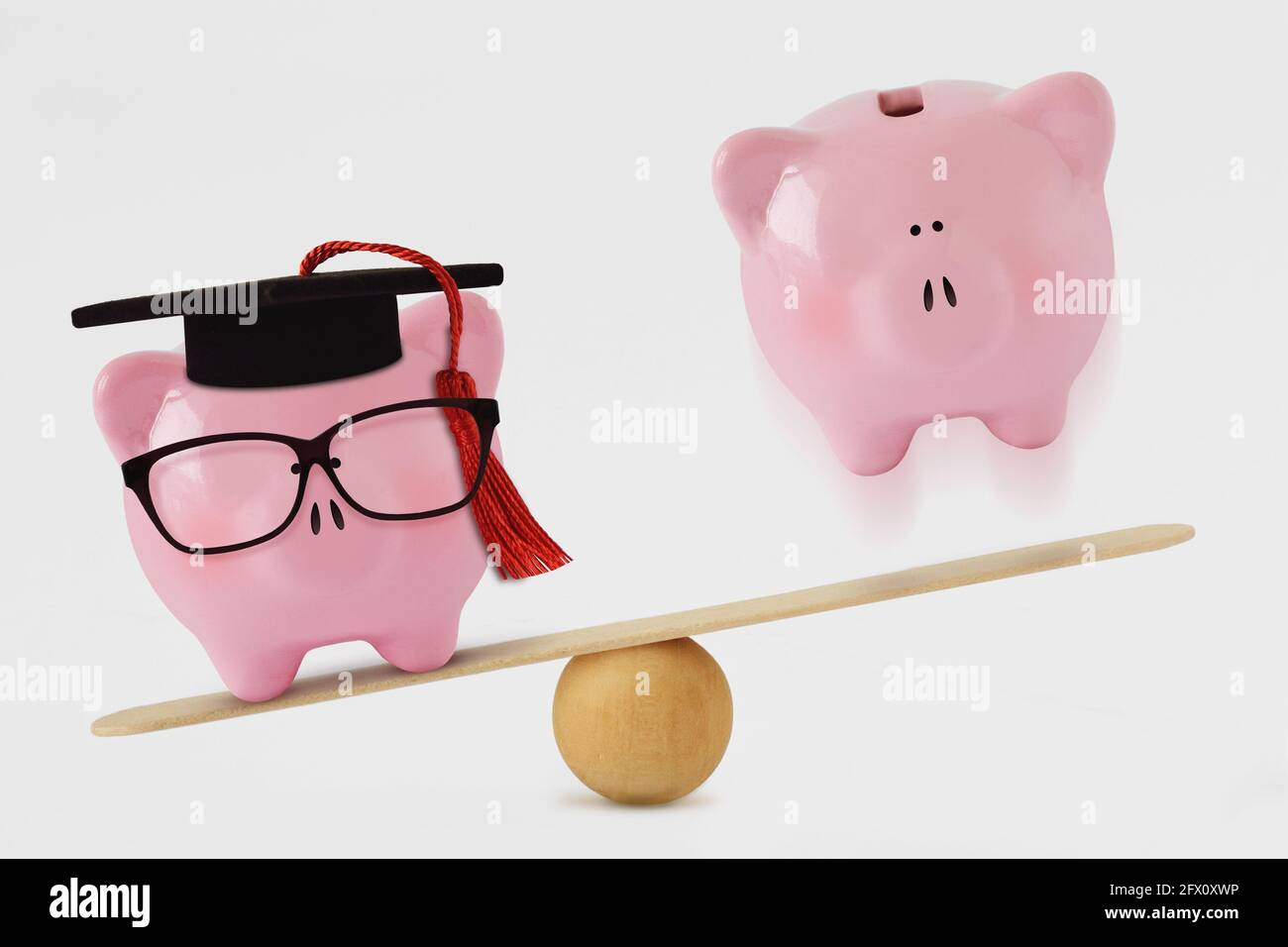Sparschwein mit Brille und Abschlusshut und schlichtem Sparschwein bank auf Saldo-Skala - Konzept der Lücke zwischen Absolventen Und nicht-Absolventinnen und Absolventen Stockfoto