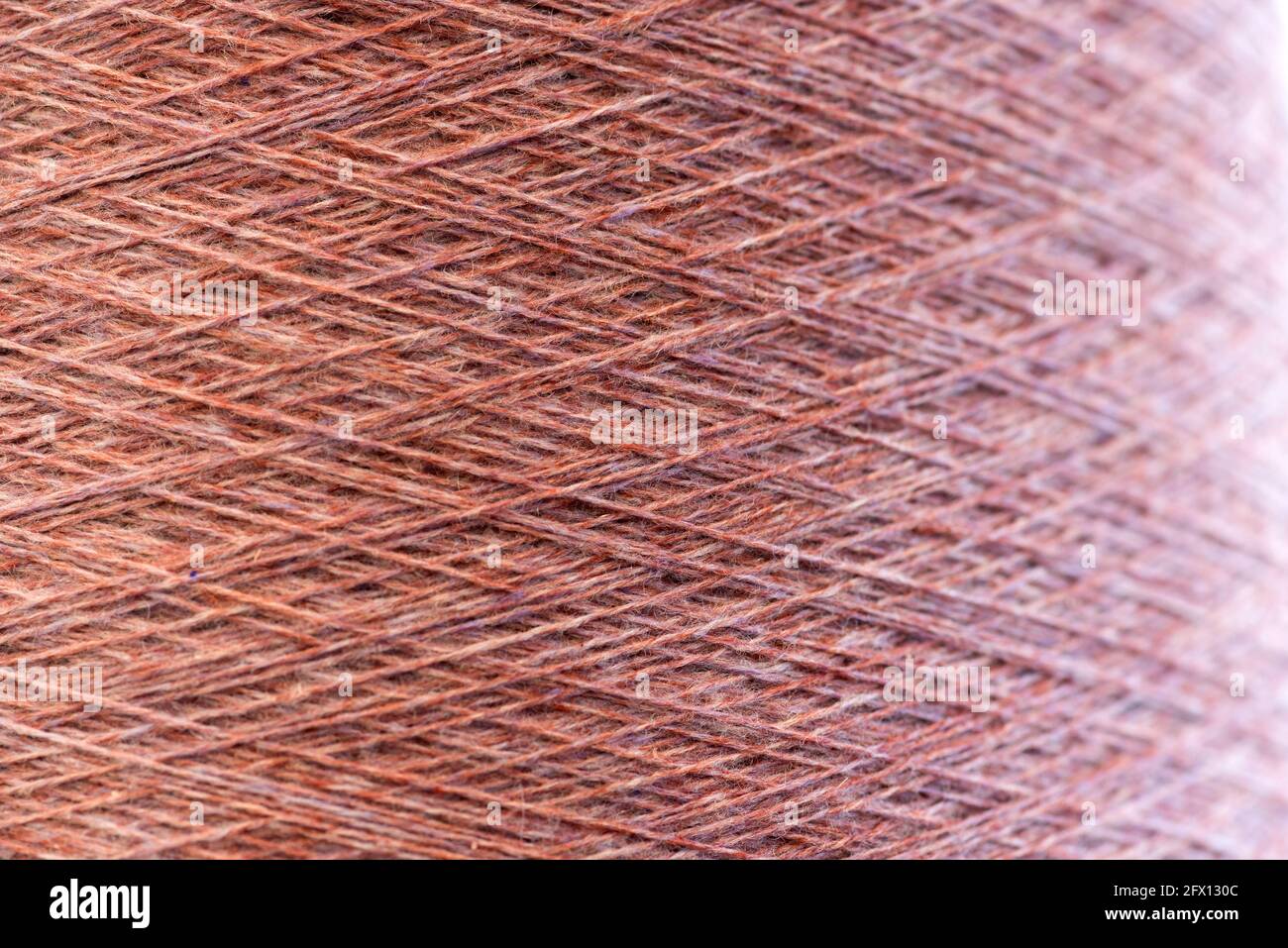 Nahaufnahme Hintergrundstruktur aus rosa Kaschmirgarn auf einer Spule Oder Rolle, die die natürlichen gesponnenen Fasern in einer Strickmode zeigt Und Modekonzept Stockfoto