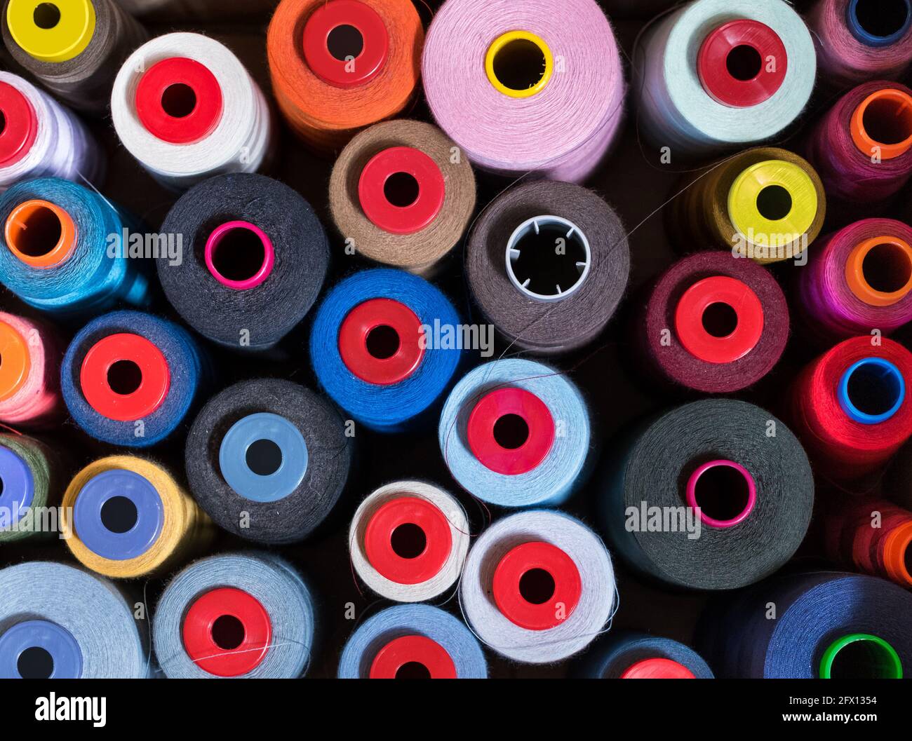 Draufsicht im Vollformat auf verschiedenen Farben von Kaschmirgarn auf Rollen oder Spulen in einer Strickfabrik In einer Produktions- und Modekonce Stockfoto