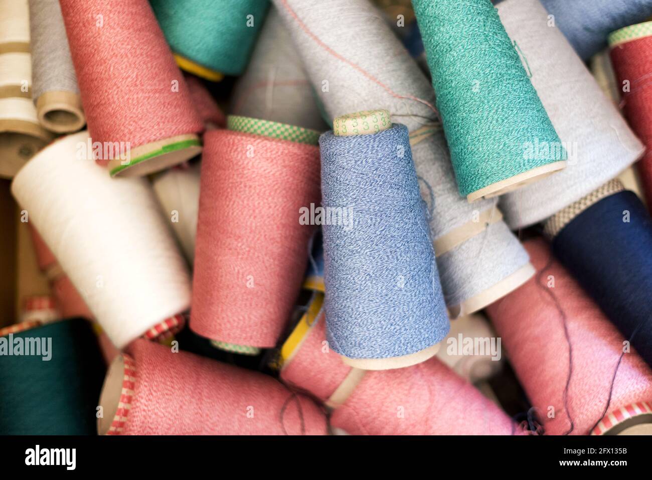 Vollformat-Hintergrundstruktur aus verschiedenen Farben aus Kaschmir-Wolle Oder Garn auf Spulen in einem zufallsartigen Jubel aus der Sicht Oben Stockfoto