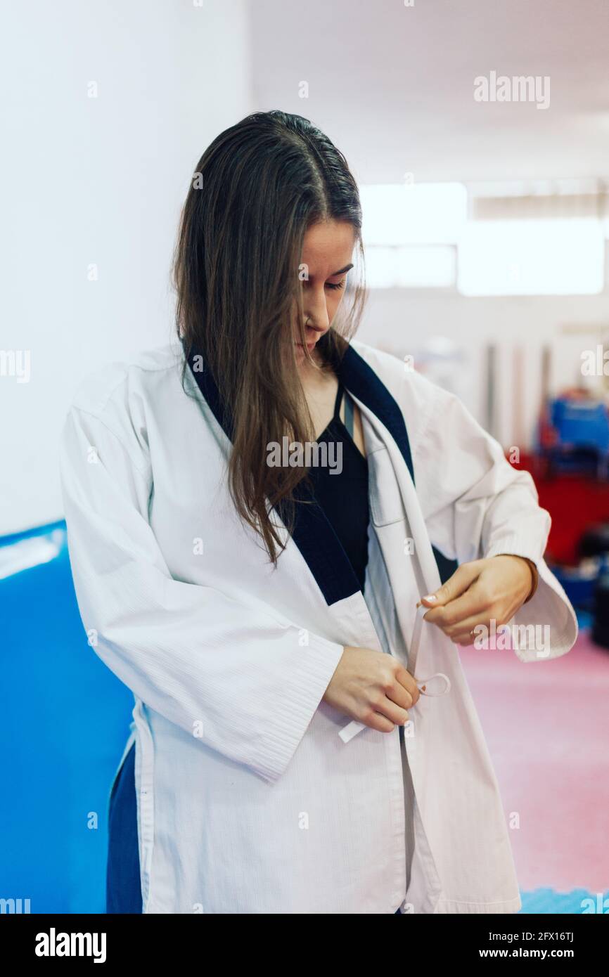 Junge Frau kleidet sich in ihren Taekwondo-Anzug Stockfoto