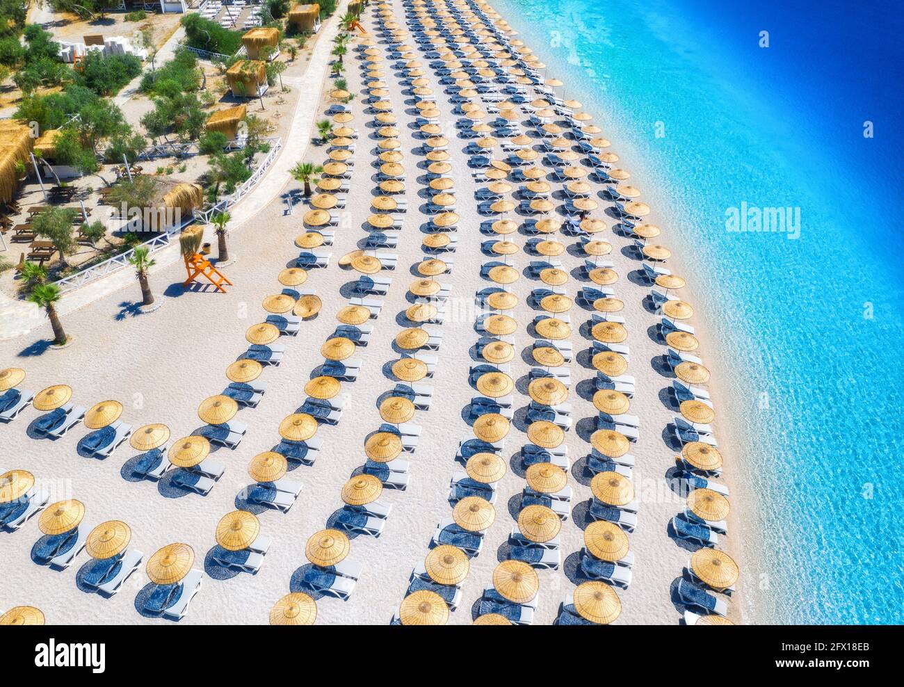Luftaufnahme des Meeres, leerer Sandstrand mit Sonnenliegen und Sonnenschirmen Stockfoto