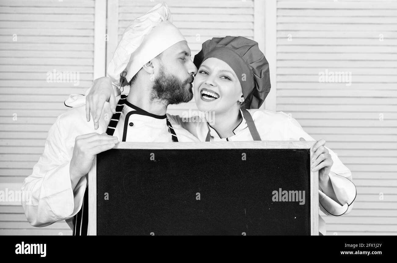 Mann und Frau Koch Kochen zusammen. Paar mit blackboard für die Werbung. Sehr nette Familie in der Küche. Family Restaurant. Tag der Familie. Paar in Stockfoto