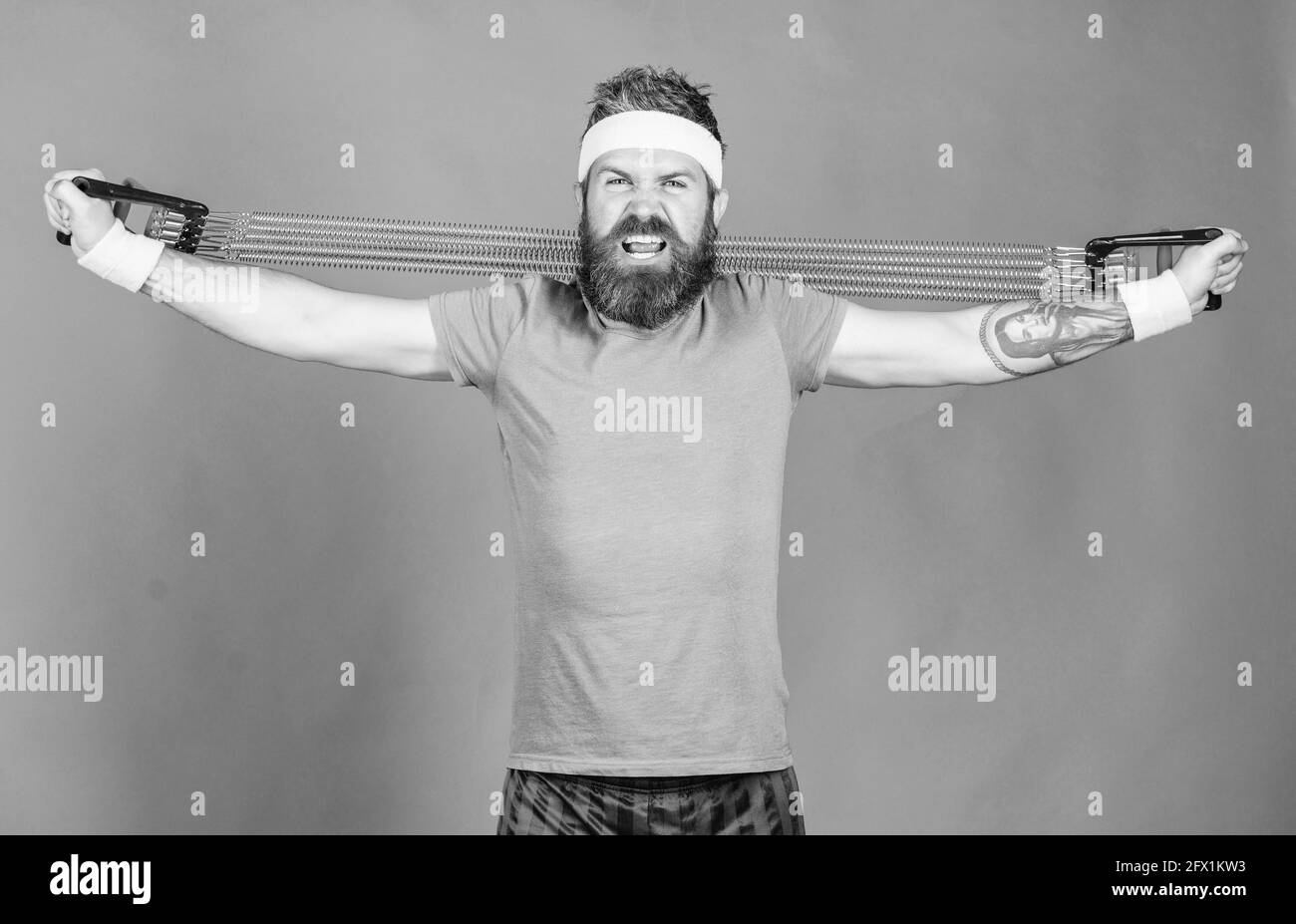 Lässt die Arme strecken. Athlet Stretching mit Expander. Mann bärtigen Athleten trainieren mit Expander-Ausrüstung. Versuchen Sie Stretching-Übung. Sportler Stockfoto